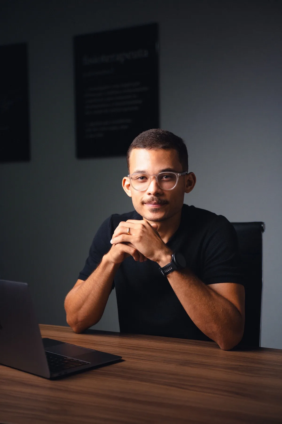 Marlon Torres sentado à mesa do consultório, com o notebook aberto