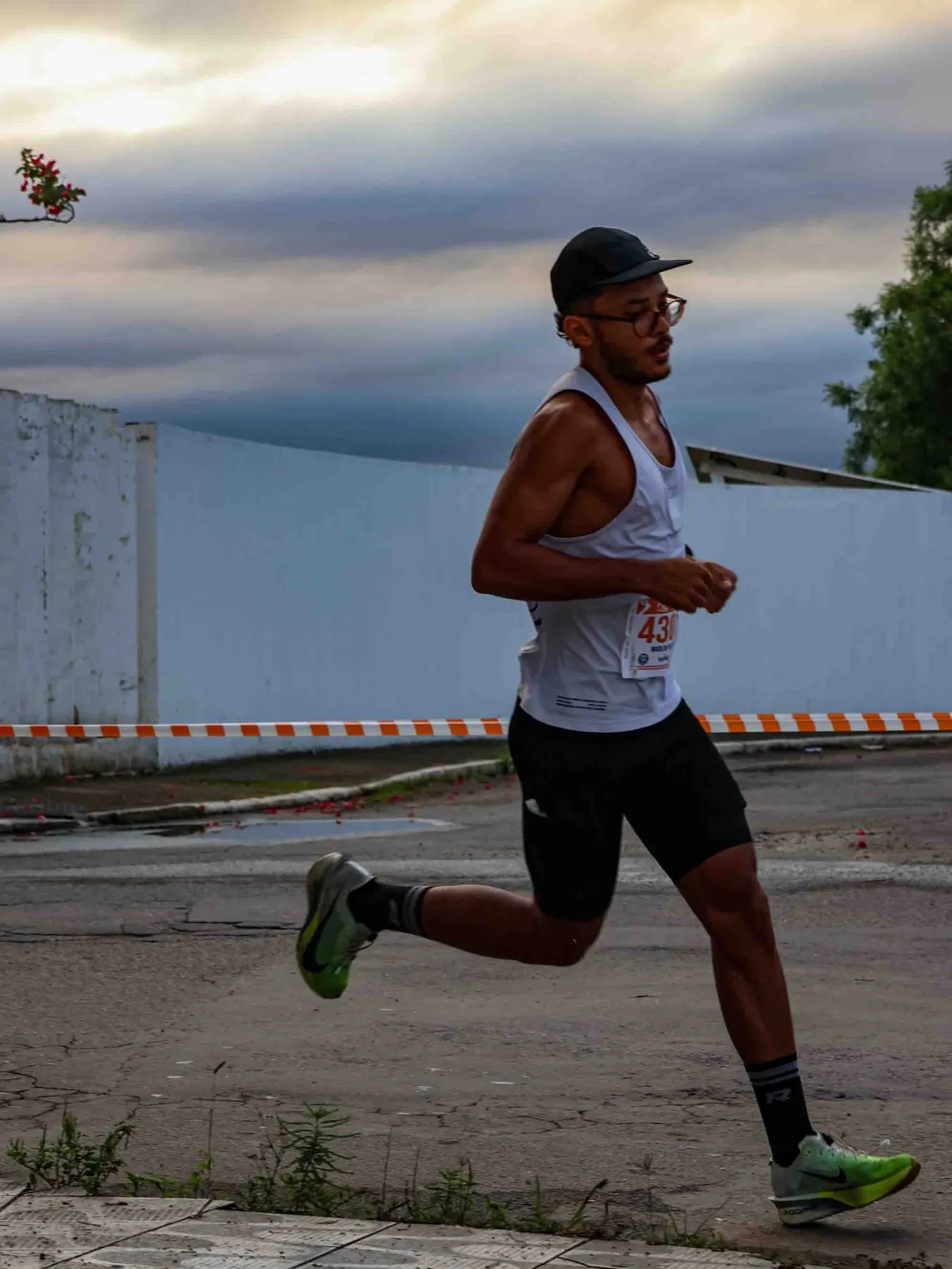 Marlon Torres correndo ao entardecer, de boné e regata branca